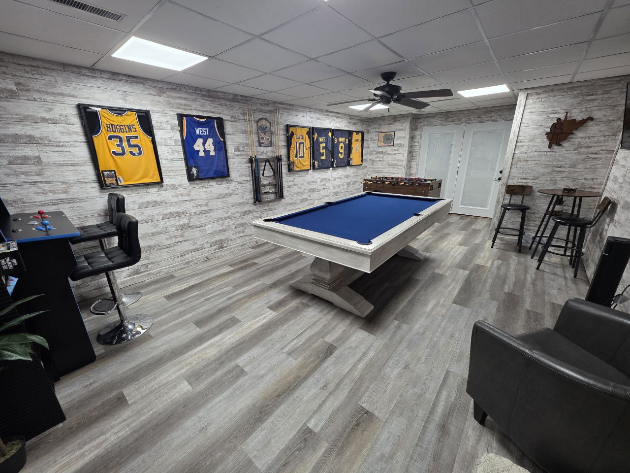 Game room with pool table and WVU Mountaineers jerseys in Morgantown vacation rental